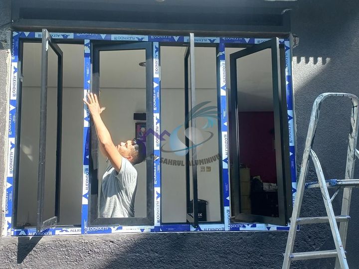 Pemasangan kusen jendela casement aluminium hitam oleh teknisi CV. Sahrul Aluminium