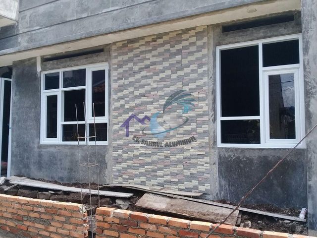 Pemasangan kusen pintu dan jendela aluminium putih pada fasad rumah oleh CV. Sahrul Aluminium