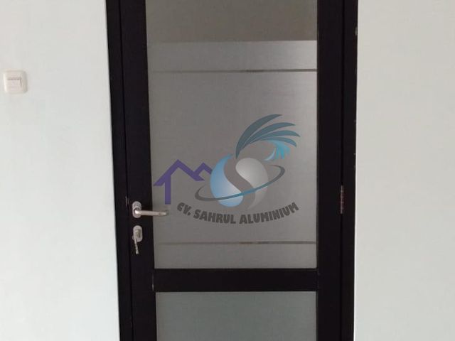 Pintu aluminium hitam dengan kaca sandblast motif garis oleh CV. Sahrul Aluminium