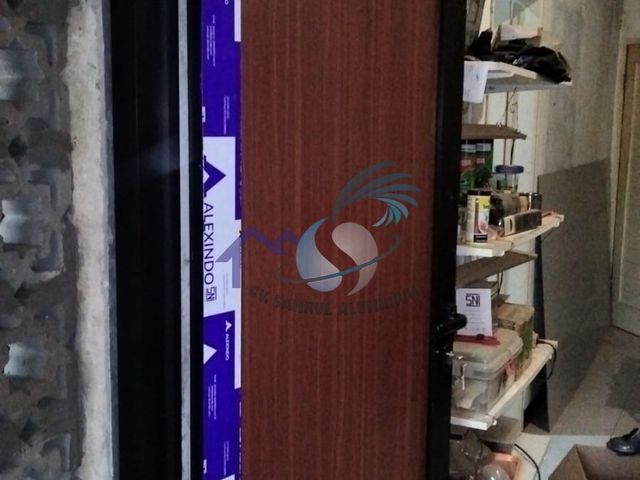 Pintu panel aluminium motif serat kayu cokelat tua buatan CV. Sahrul Aluminium