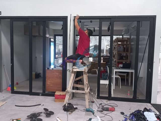 Pemasangan pintu geser dan partisi depan toko aluminium hitam oleh CV. Sahrul Aluminium
