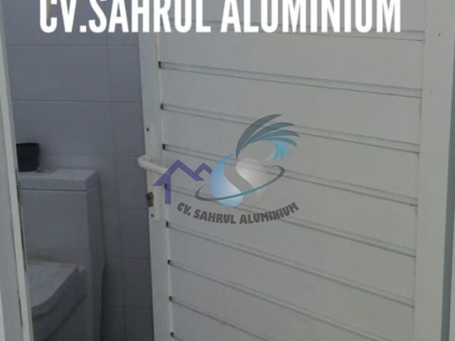 Pemasangan pintu jalusi aluminium putih tahan air oleh CV. Sahrul Aluminium