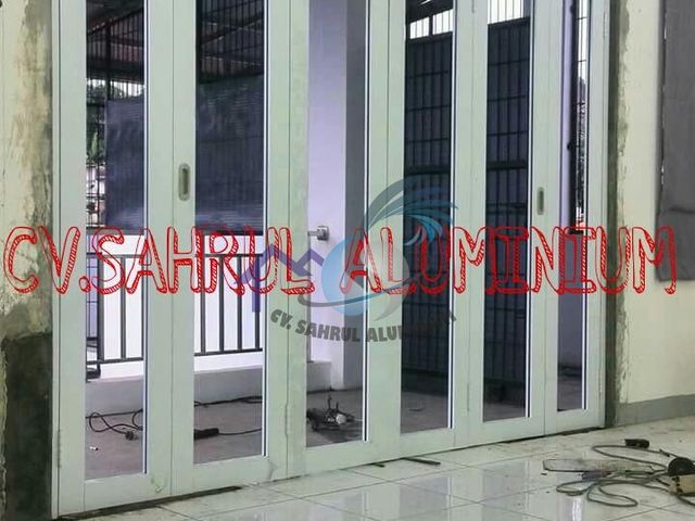 Pintu lipat aluminium putih 6 daun kaca bening buatan workshop CV. Sahrul Aluminium