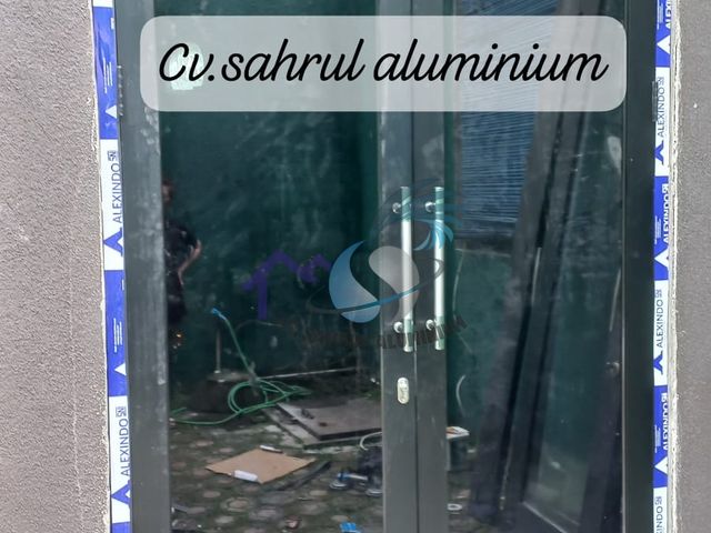 Pemasangan pintu ganda kaca bingkai aluminium hitam oleh CV. Sahrul Aluminium